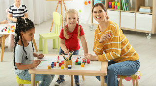 Técnica de FP Educación Infantil a distancia trabajando con dos niñas en un aula infantil